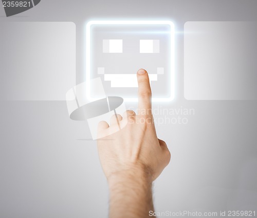 Image of hand touching virtual screen with smile button