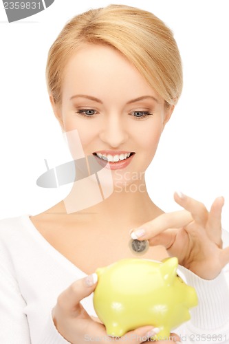 Image of woman with small piggy bank and coin