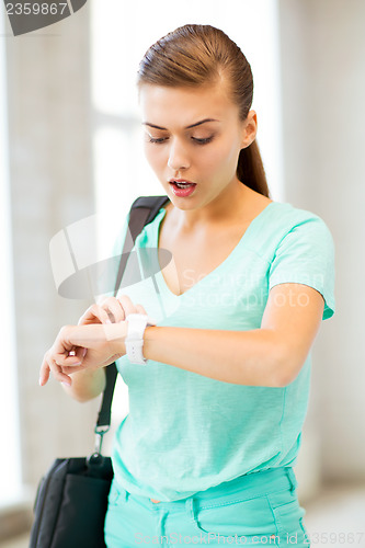 Image of surprised student girl looking at clock