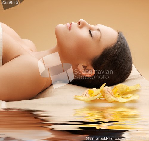 Image of woman in spa salon lying on the massage desk