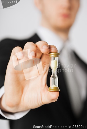 Image of man hand holding hourglass