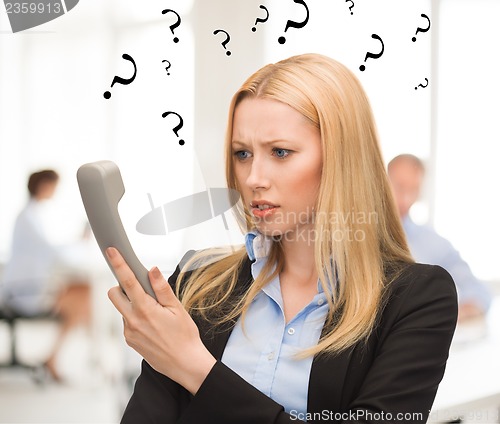 Image of confused woman with phone in office