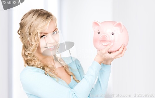 Image of lovely woman with piggy bank