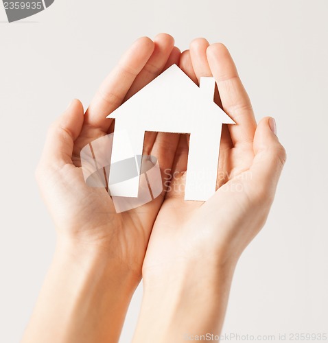 Image of woman hands with paper house