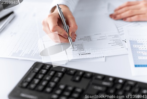 Image of woman hand filling in invoice paper