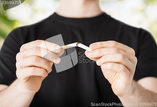 Image of man breaking the cigarette with hands