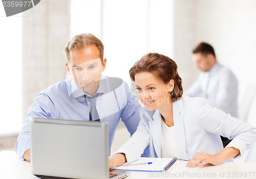 Image of man and woman working with laptop in office