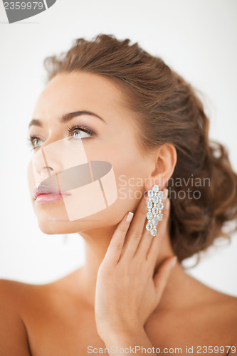 Image of woman wearing shiny diamond earrings