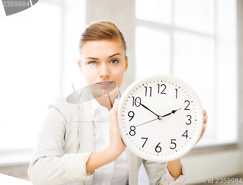 Image of attractive businesswoman showing white clock