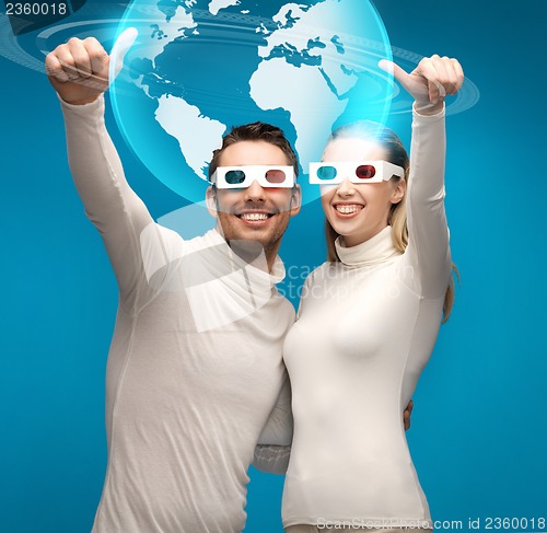 Image of woman and man in 3d glasses looking at globe model