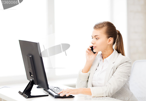 Image of businesswoman with smartphone in office