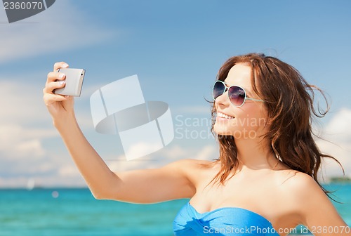 Image of woman in bikini with phone