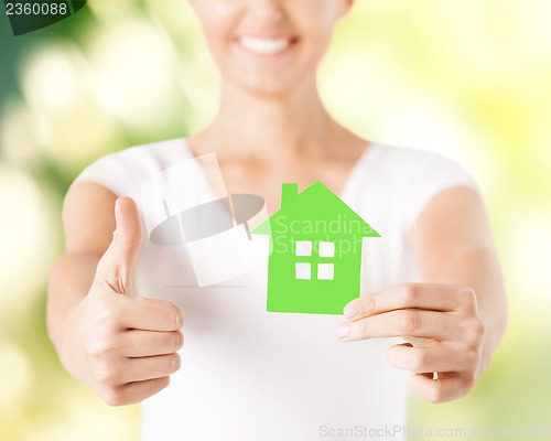 Image of woman hands holding green house