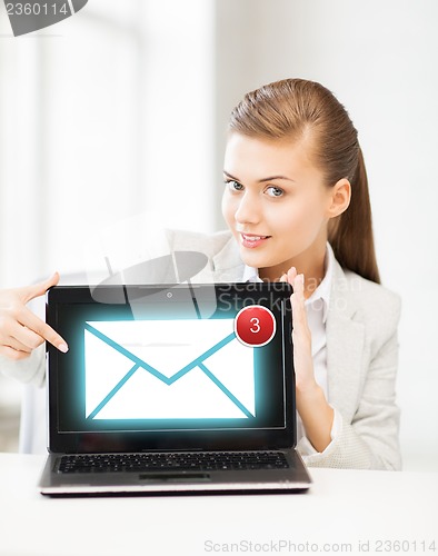 Image of businesswoman with laptop in office