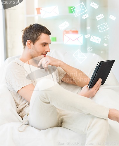 Image of man sitting on the couch with tablet pc