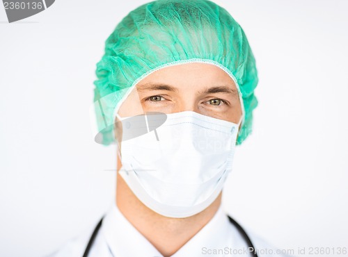 Image of surgeon in medical cap and mask