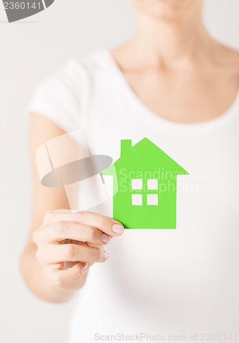 Image of woman hands holding green house