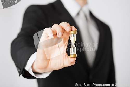 Image of man hand holding hourglass