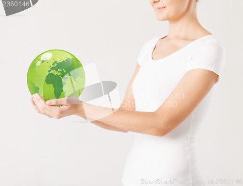 Image of woman holding green sphere globe