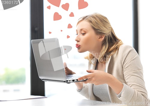 Image of woman with computer kissing the screen