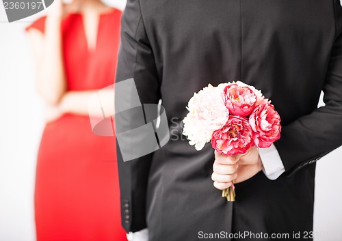 Image of man hiding bouquet of flowers