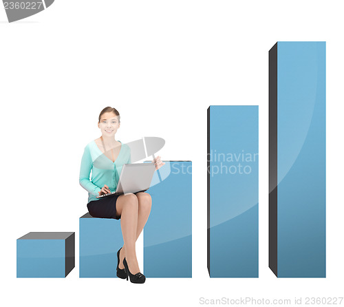 Image of businesswoman sitting on big 3d chart