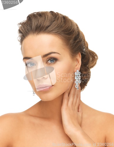 Image of woman wearing shiny diamond earrings
