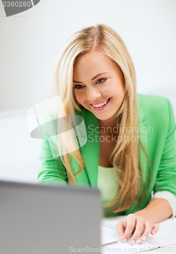 Image of businesswoman with laptop in office