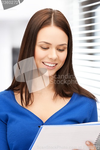 Image of smiling young businesswoman with notebook