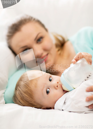 Image of mother and adorable baby with feeding-bottle