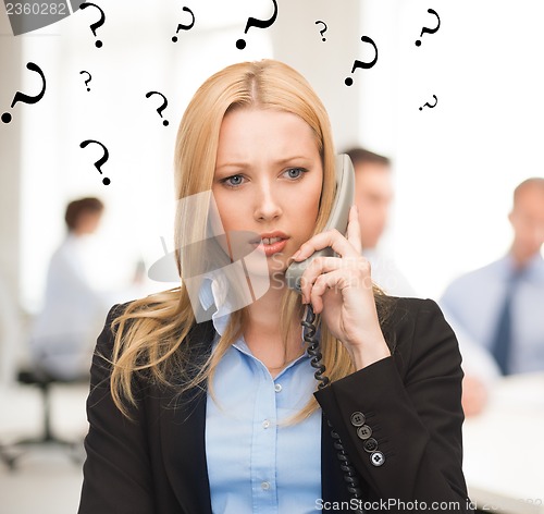 Image of confused woman with phone in office