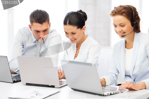 Image of group of people working with laptops in office