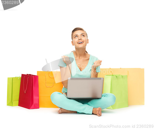 Image of woman with laptop and shopping bags