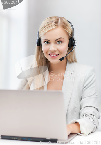 Image of friendly female helpline operator with laptop