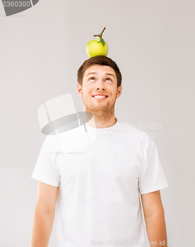 Image of man with green apple on his head