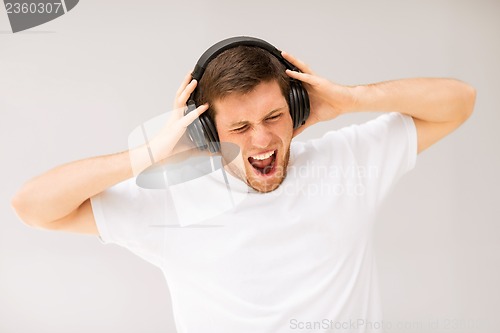 Image of man with headphones listening loud music