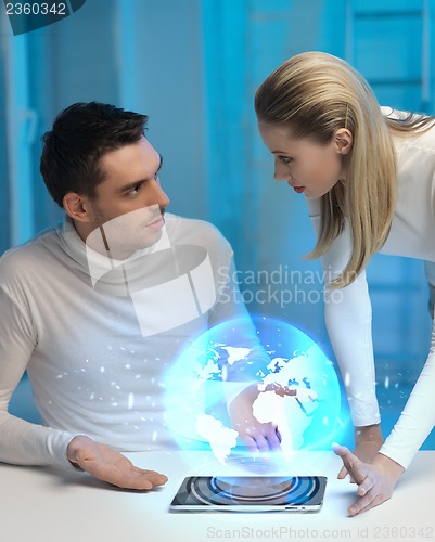 Image of futuristic man and woman with globe hologram