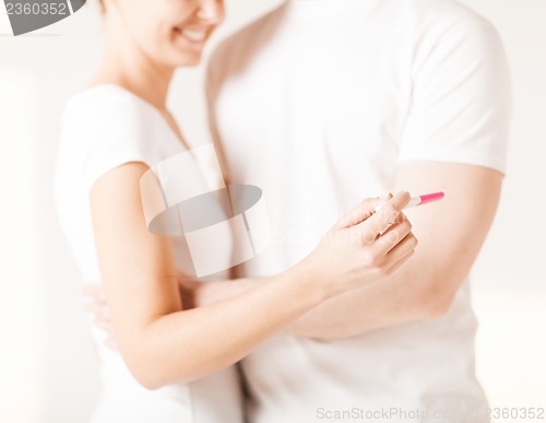 Image of woman and man hands with pregnancy test