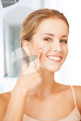 Image of beautiful woman pointing to nose