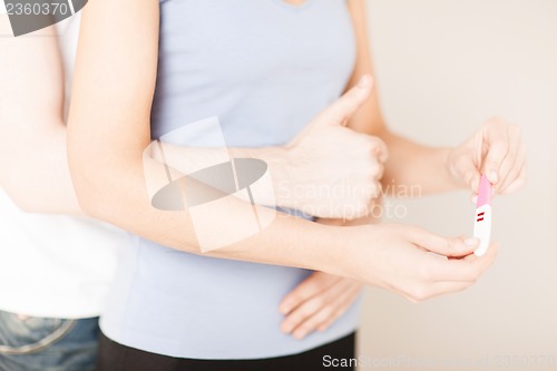 Image of woman and man hands with pregnancy test