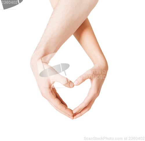 Image of woman and man hands showing heart shape