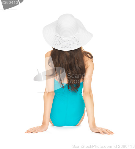 Image of model sitting in swimsuit with hat