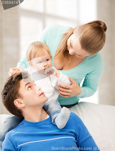 Image of happy parents playing with adorable baby