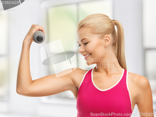 Image of young sporty woman with light dumbbell