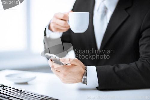 Image of man hands with keyboard, smartphone and coffee