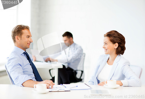 Image of man and woman discussing something in office