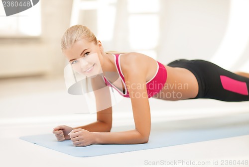 Image of sporty woman doing exercise on the floor