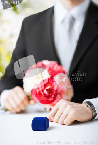 Image of man with gift box in suit