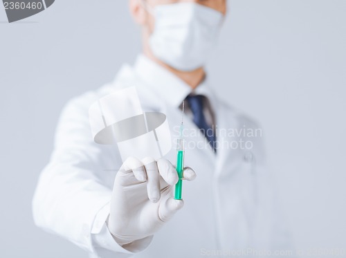 Image of male doctor holding syringe with injection