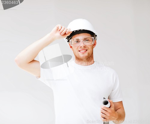 Image of male architect in helmet with blueprint